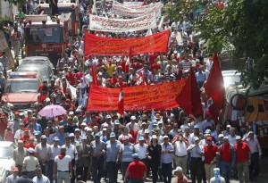 Lebanese leftist activists wave Lebanese and communist flags as they march during a demonstration to mark Labour Day, or May Day, along a street in Beirut