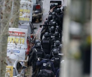 Members of the French national police intervention group (BRI) arrive at the scene where a female police officer was shot dead in Montrouge, a southern suburb of Paris on January 8, 2015, a day after Islamist gunmen stormed the office of satirical magazine Charlie Hebdo, killing eight journalists, two police and two others. A policewoman who was shot by a gunman wearing a bullet-proof vest just outside Paris has died and a second victim is in serious condition, police said on January 8. The man escaped after the attack on Thursday morning, which comes just a day after a deadly Islamist assault on satirical magazine Charlie Hebdo left 12 dead, although no link has yet been established between the two incidents.   AFP PHOTO/ KENZO TRIBOUILLARD