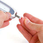 Diabetic is doing a glucose level finger blood test.