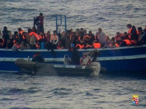 A handout photo released by the Italian Navy on March 18, 2014 and taken on March 17, 2014 shows migrants standing on a boat during a rescue operation carried out by the Italian Navy near the Italian island of Lampedusa. The Italian navy said it had rescued nearly 600 Syrian, Palestinian and Eritrean migrants crossing the Mediterranean in two overcrowded boats, including 62 minors. The Italian frigate Grecale pulled 323 Syrians and Palestinians to safety late on Monday, after helping rescue another 273 migrants from Eritrea, who were taken aboard the gunboat Sfinge, the navy said in a statement. AFP PHOTO / ITALIAN NAVY - RESTRICTED TO EDITORIAL USE - MANDATORY CREDIT "AFP PHOTO / ITALIAN NAVY " - NO MARKETING NO ADVERTISING CAMPAIGNS - DISTRIBUTED AS A SERVICE TO CLIENTS