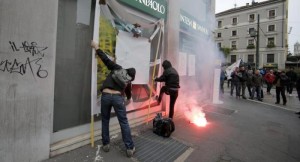 Demonstrators throw paint on a bank window during a protest against the Milan's Universal Exposition, EXPO2015 in Milan, 01 May 2015.    ANSA/MASSIMO PERCOSSI