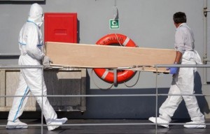 Rescuers carry a coffin off the Irish military vessel Naimh  after its arrival in the port of Palermo on August 6, 2015, with 367 survivors aboard and 25 coffins, following a rescue operation at sea of  a boat carrying over 600 migrants that capsized in the Mediterranean Sea off the Libyan coast. Survivors of a shipwreck off the coast of Libya in which some 200 migrants were feared drowned were being brought to safety in Sicily on August 6, as tales emerged of the 'horrific' moment the boat overturned.   AFP PHOTO / MARCELLO PATERNOSTRO