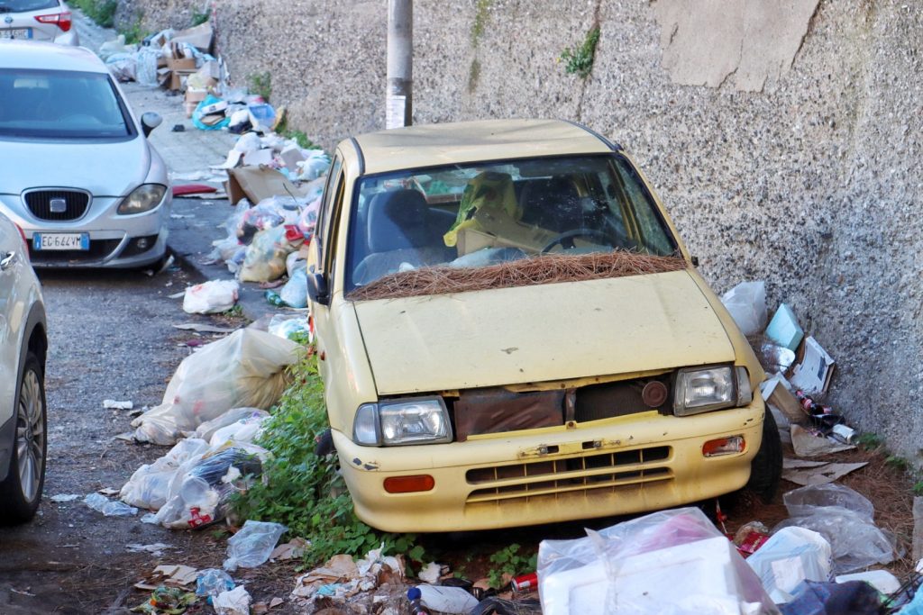 Macchina abbandonata e spazzatura in via Trieste