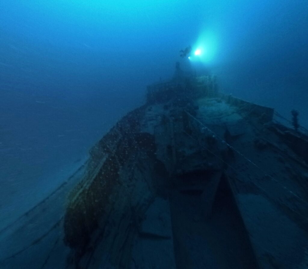 La-prua-del-relitto-Andrea-Murdock-Alpini-illumina-la-prua-del-relitto-Carlo-Martinolich-foto-Andrea-Fattore-Courtesy-PHY-Diving-Equipment.jpg 9 Giugno 2025