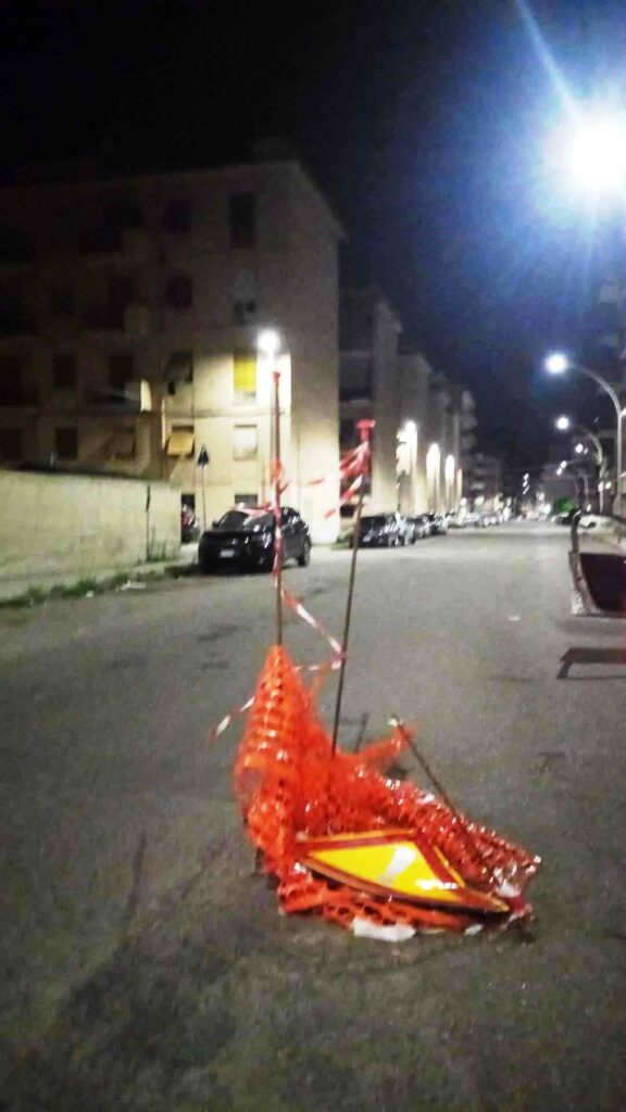 voragini recintate con il nastro arancione e abbellite con lanterne cinesi