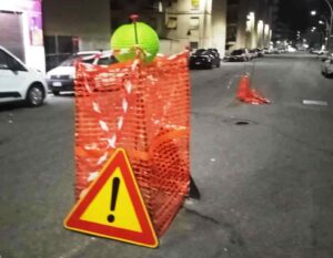 voragini recintate con il nastro arancione e abbellite con lanterne cinesi