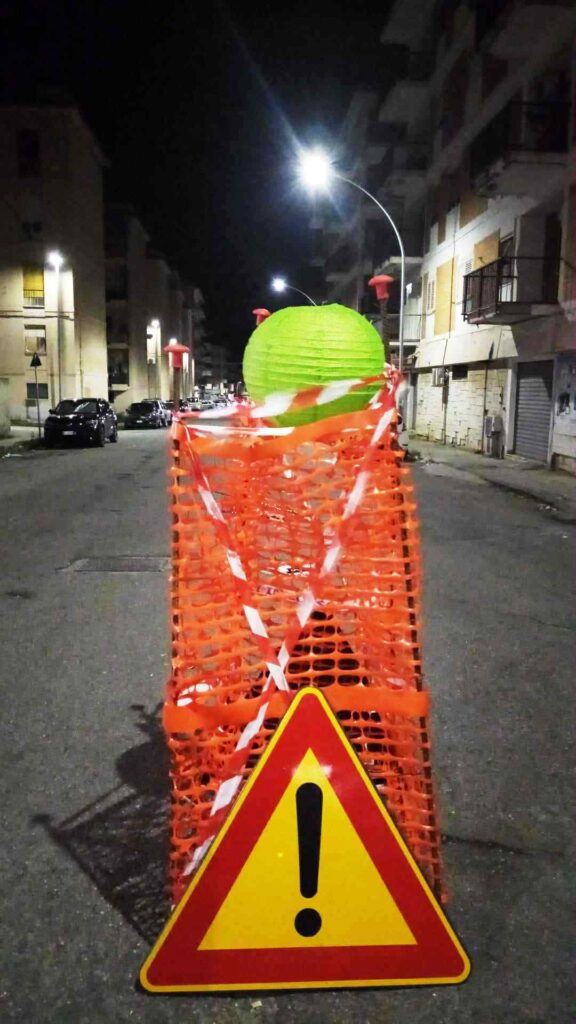 voragini recintate con il nastro arancione e abbellite con lanterne cinesi