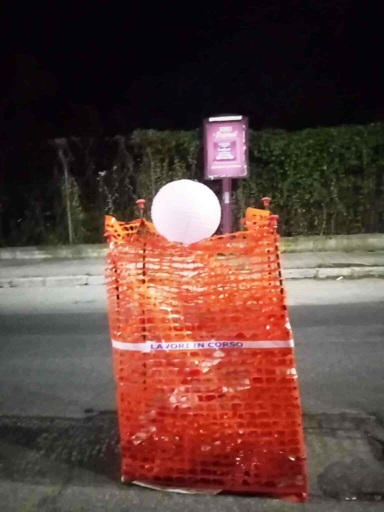 voragini recintate con il nastro arancione e abbellite con lanterne cinesi