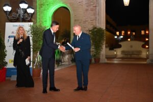 Il Direttore Generale di Poste Italiane, Giuseppe Lasco, ritira il premio dal Presidente dell'Associazione La Caramella Buona, Roberto Mirabile