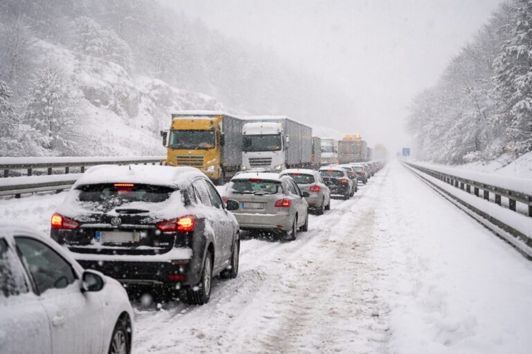 auto in coda con la neve sull'autostrada
