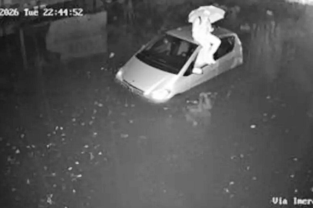 automobilista bloccato tetto auto per il maltempo