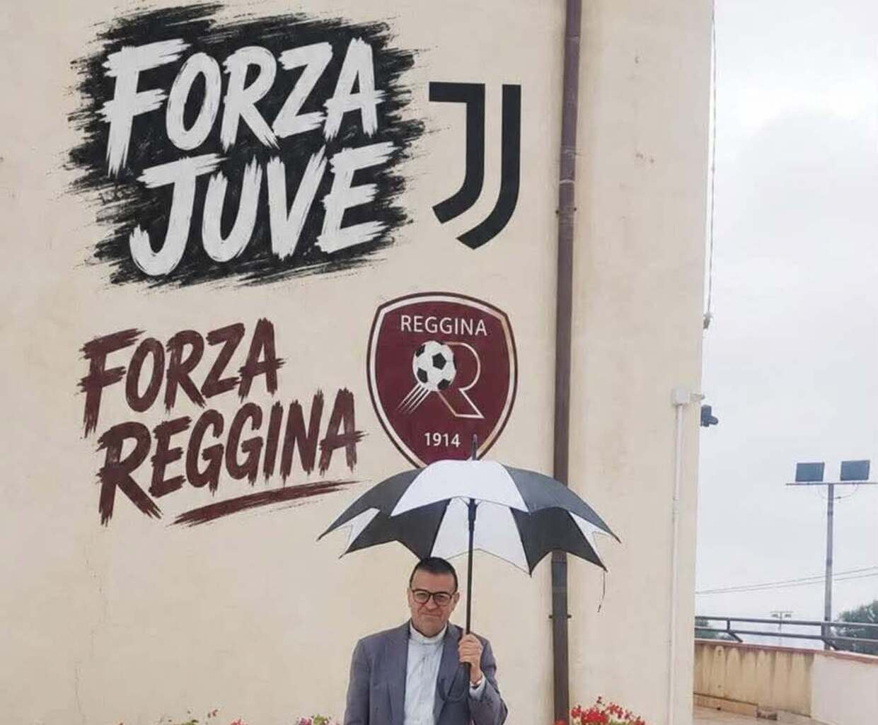 don zampaglione sotto la pioggia protetto dall’ombrello della juve