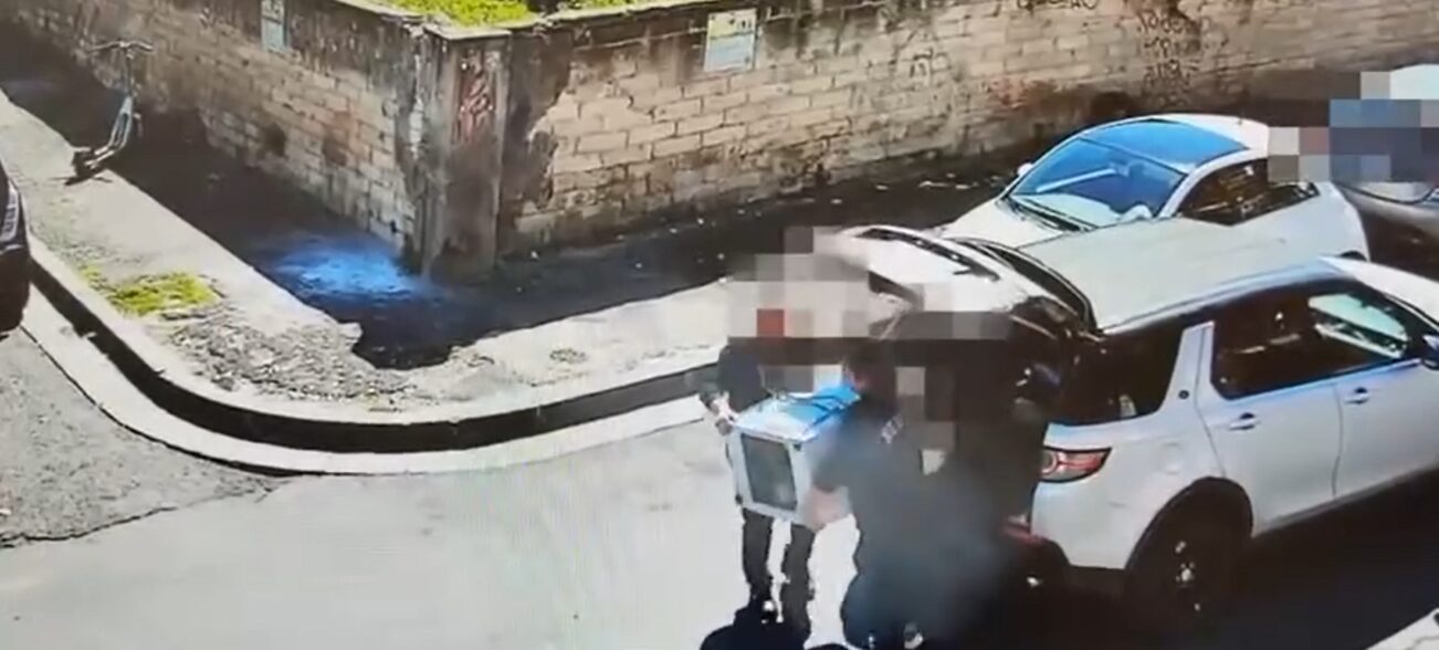 uomini scaricano lavatrice in strada a Catania