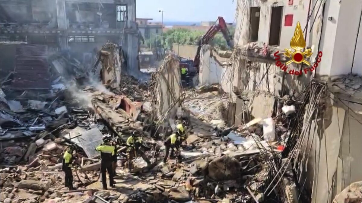 Vigili del fuoco e squadre di soccorso rimuovono detriti dopo il crollo di una palazzina a Messina